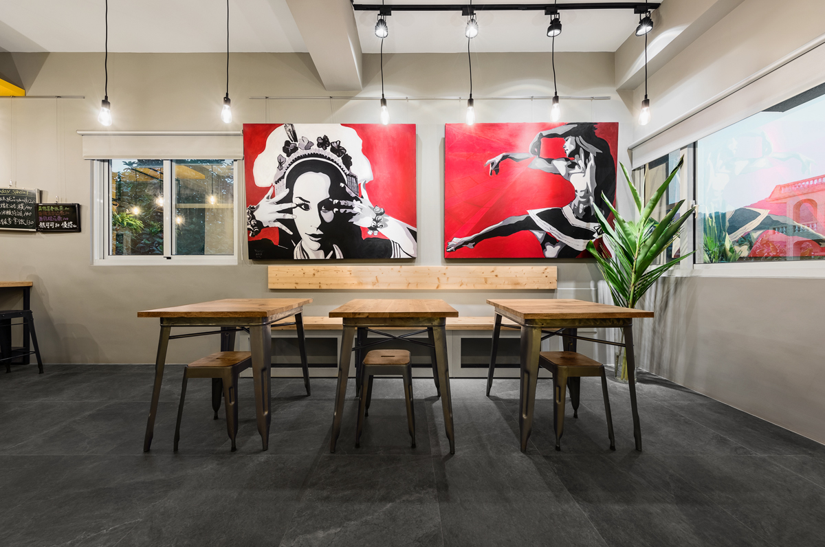 咖啡廳店面設計：深色地板和以紅、黑為主色的原住民風格繪畫，引人注目的同時也增強了在地的文化表達。