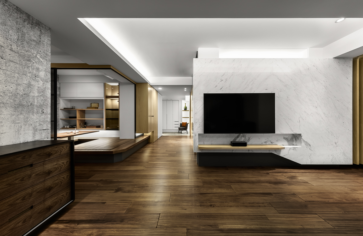 三房兩廳是大多數人能負擔得起的空間規格，透過空間設計整體規劃，採用低彩度的黑、白、灰色系做為空間色彩主調，展現不退流行的Chic Style。在色系選擇上，以具有放大空間效果的白色為主色調，在低彩度中融入溫潤自然木質元素，帶有溫度原木色從公共區域延伸至各房間，為空間注入原木色暖意。我們也善用線條的變化從電視牆到架高地坪切角，讓空間設計更饒富趣味，即便是位在房子中央，也能透過空間設計變得可開放可隱密，兼具多功能性。